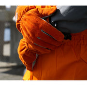 Närbild på HERO-handskar i viloposition – orange läderyta med ergonomisk passform för handled och knoge.