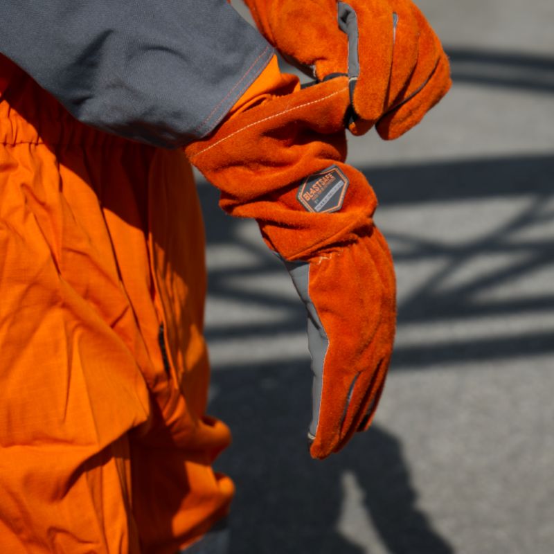 Blastsafe™ HERO-handskar i användning – visar logotyp, struktur och sömnad längs ärmslut och handled.