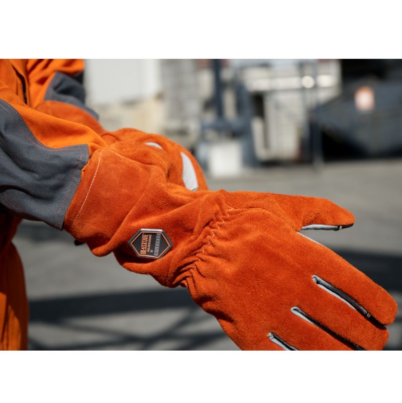 Användaren tar på sig Blastsafe™ HERO-handskar – visar ergonomisk passform och yttre sömmar.