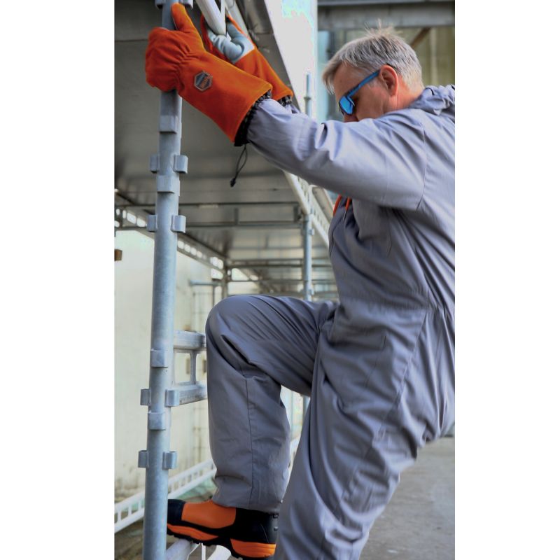 Användaren tar på sig Blastsafe™ HERO-handskar – visar ergonomisk passform och yttre sömmar.