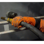 Blästringsarbete med IRONGRIP-handskar – operatör håller i blästerslang och utrustning.