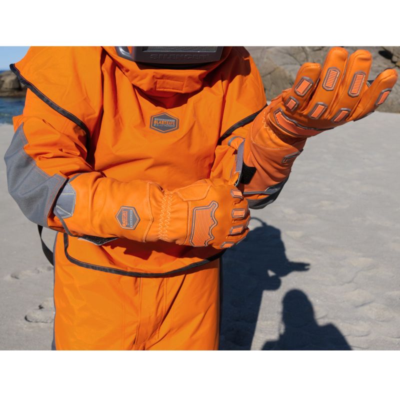 Två händer med Blastsafe™ IRONGRIP-handskar i färdig position – redo för blästringsarbete i fält.