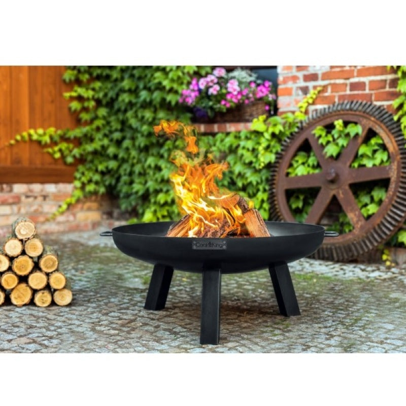 Eldfat POLO från Cook King med brinnande ved i trädgårdsmiljö