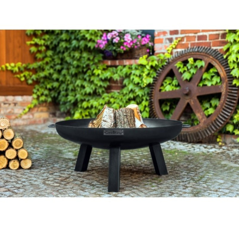 Eldfat POLO från Cook King med ved, placerat på stenlagd uteplats