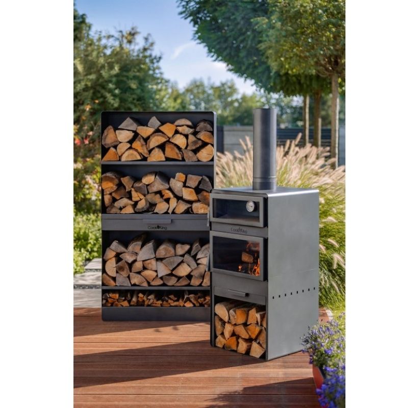 Närbild på eldstaden i kamin med ved under pizzaugnen.