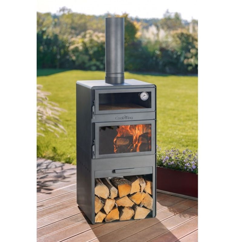 Kaminens utdragbara asklåda med ved förvarad under.