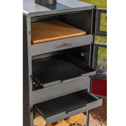 Trädgårdskamin i närbild med öppen eld och bakugn med termometer.