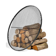 Rundt grillgaller i naturligt stål, lutat mot en hög vedträn 