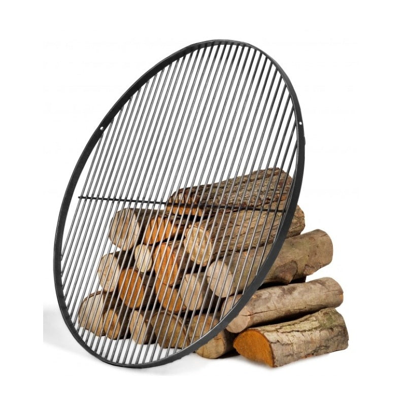 Rundt grillgaller i naturligt stål, lutat mot en hög vedträn 