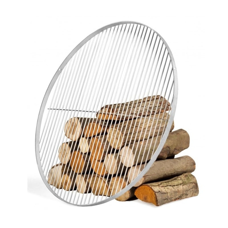 Rundt grillgaller i rostfritt stål, lutat mot en hög vedträn – produktbild