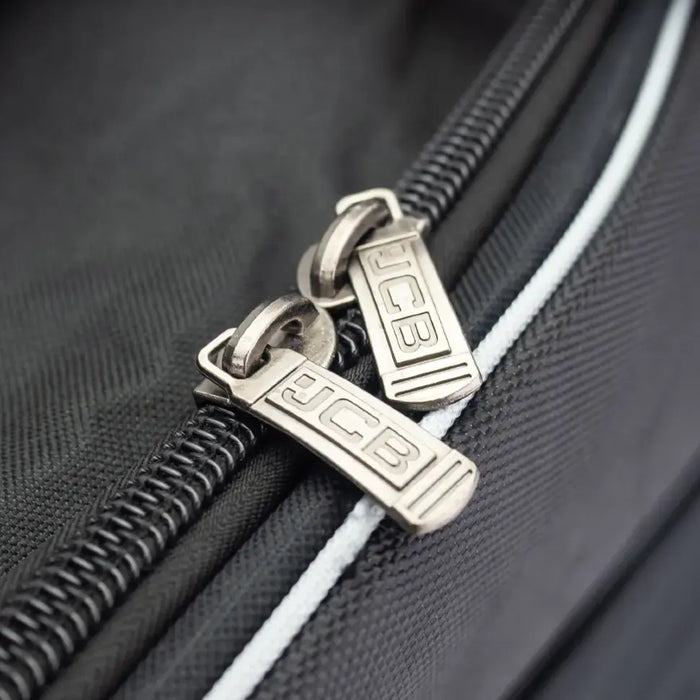 Detaljbild på dragkedja och fäste på JCB verktygsväska 26”.