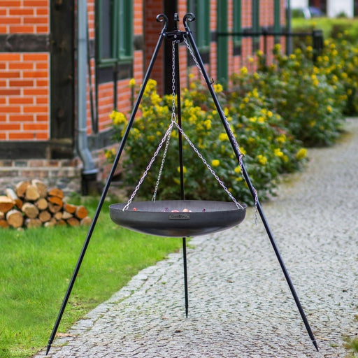 Tripod med hängande tom wokskål från Cook King på grusgång