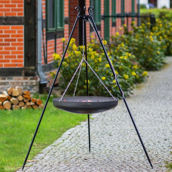 Tripod med hängande tom wokskål från Cook King på grusgång