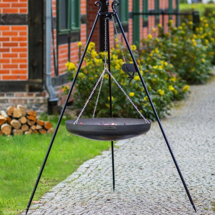 Tripod med hängande wok och vinschsystem från Cook King i trädgårdsmiljö