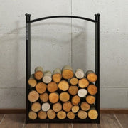 Närbild på nedre delen av vedstället CHERRY med staplad ved